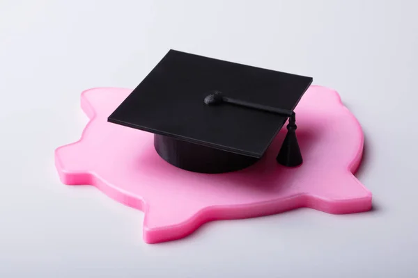 Nahaufnahme Von Graduiertenmütze Und Flachem Rosa Sparschwein Auf Weißem Hintergrund — Stockfoto