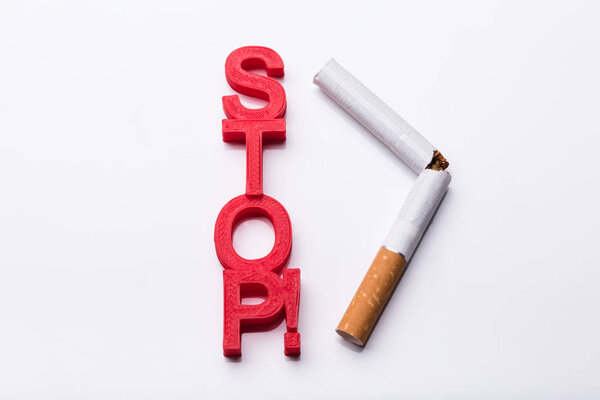 Elevated View Of Red Cubic Blocks Near Broken Cigarette On White Background