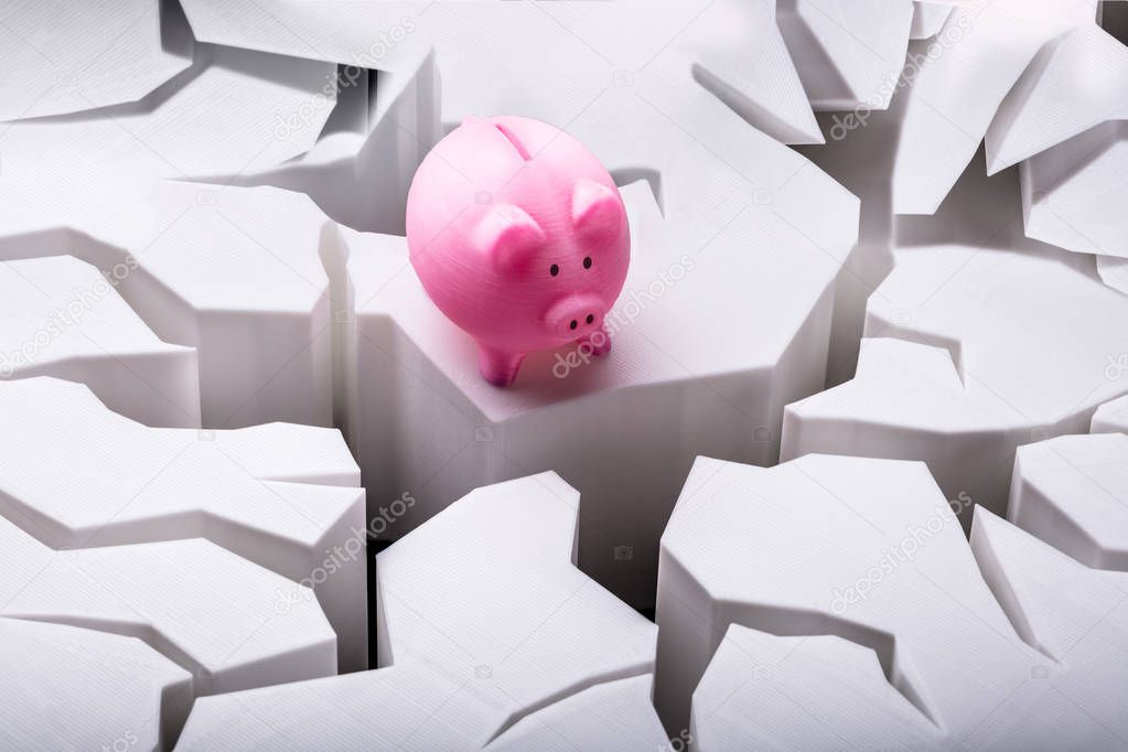 Elevated View Of Pink Piggybank On Cracked White Surface