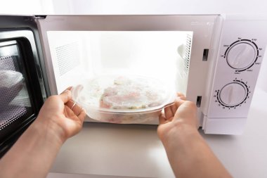 Mikrodalga fırında yemek Isıtma bir kadın eli Close-up