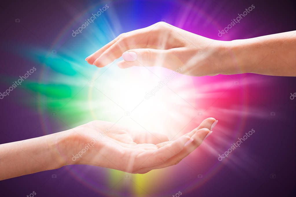 Close-up Of A Woman's Hand Holding Light Against Colorful Background