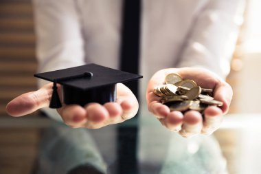 Siyah mezuniyet şapka ve altın sikke Resepsiyon üzerinde tutan eller