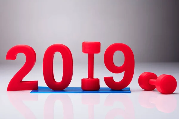 Año 2019 Sobre Esterilla Ejercicio Cerca Mancuerna Roja Escritorio Reflectante — Foto de Stock