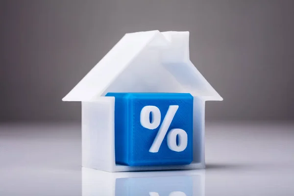 反射背景下住宅模型中百分比符号的蓝色立方体 — 图库照片