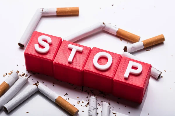 Röd Stoppa Kubiska Block Omgiven Trasiga Cigaretter Vit Bakgrund — Stockfoto