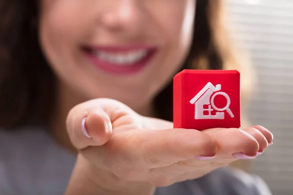 ホーム検索アイコンを持つ赤の立方ブロックを持っている女性の手のクローズ アップ — ストック写真