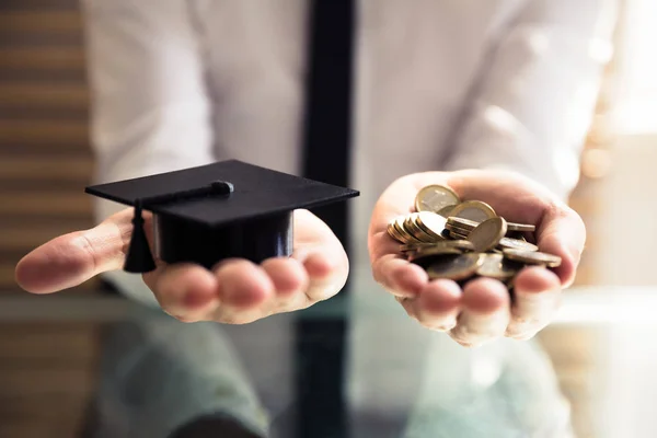 Mano Humana Sosteniendo Sombrero Graduación Negro Monedas Oro Sobre Escritorio — Foto de Stock