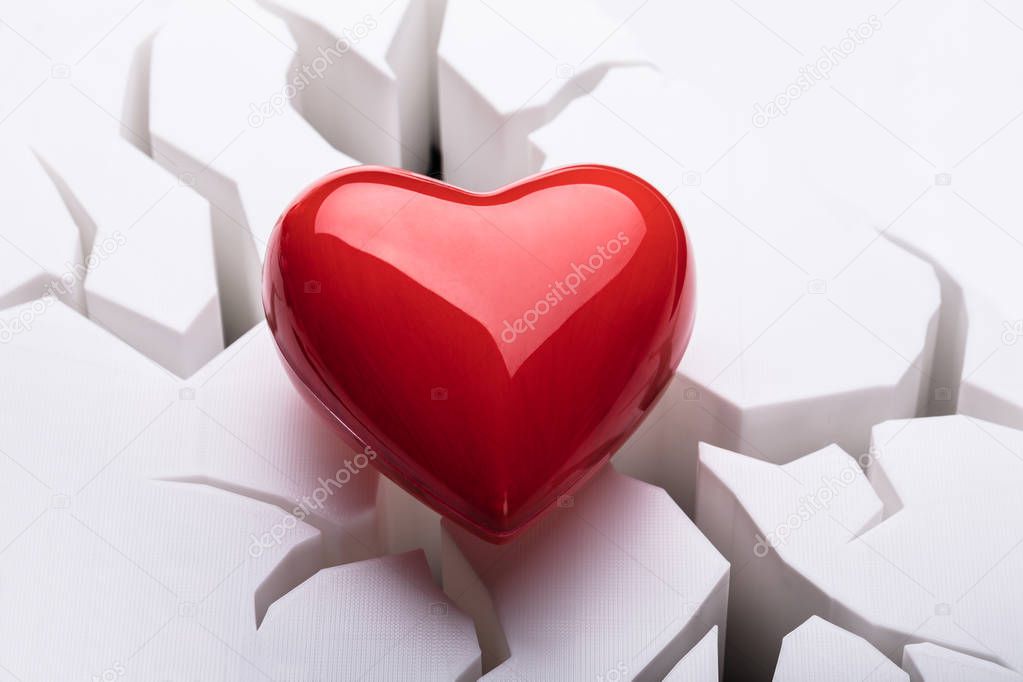 High Angle View Of Red Heart On Cracked White Background
