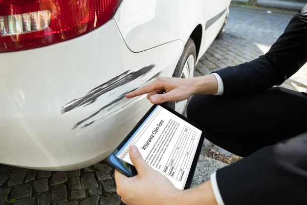 Persons Hand Undersöka Skadad Bil Samtidigt Fylla Skadeanmälan Digitala Tablett — Stockfoto