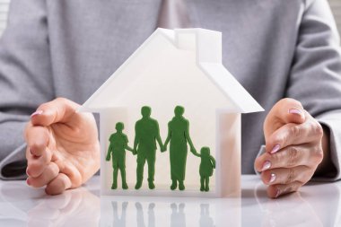 Ev Model üstünde okul sırası içinde aile rakamlar koruyan bir kadın eli Close-up