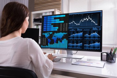 Female Stock Market Broker Analyzing Graphs On Computer At Workplace clipart