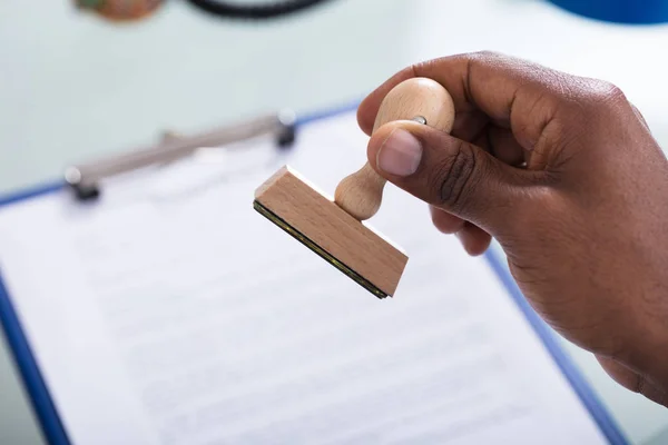 Close Hand Holding Wooden Stamp Defocused Document — Stock Photo, Image