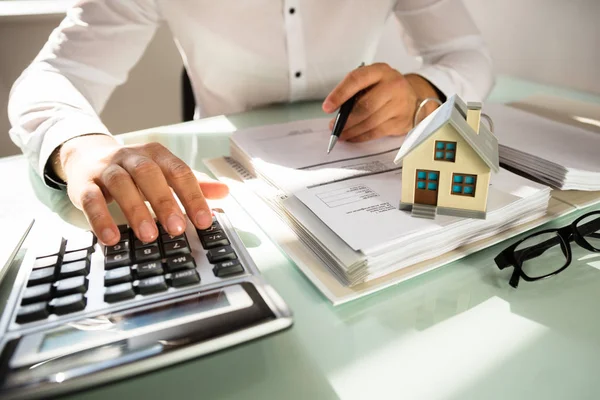 Mão Empresário Calculando Fatura Com Modelo Casa Escritório — Fotografia de Stock