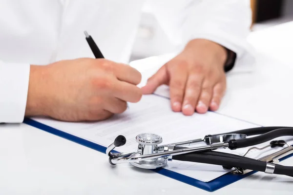 Doctor Hand Signing Document Stethoscope Desk — Stock Photo, Image