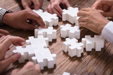 Beyaz Jigsaw bulmaca çözme işgal birlikte ahşap masanın üzerinde