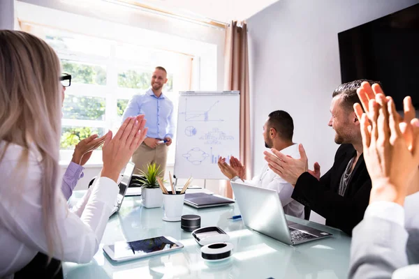 Empresarios Aplaudiendo Sonriente Colega Masculino Después Presentación Lugar Trabajo — Foto de Stock