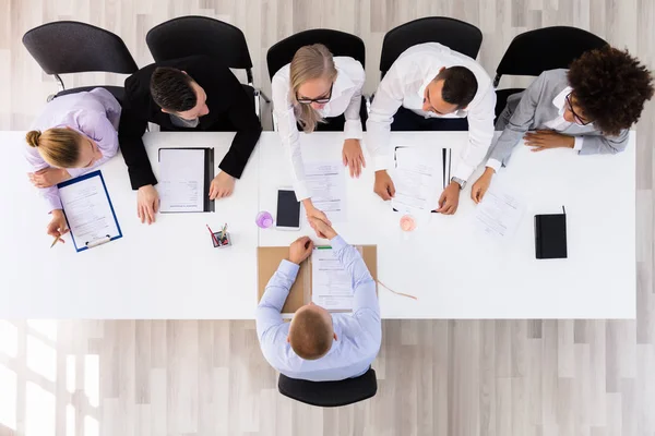 Genç adam görüşmede kadın elini sıkarken gülümseyen