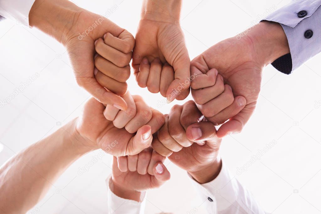 Low Angle View Of Businesspeople Making Fist Bump