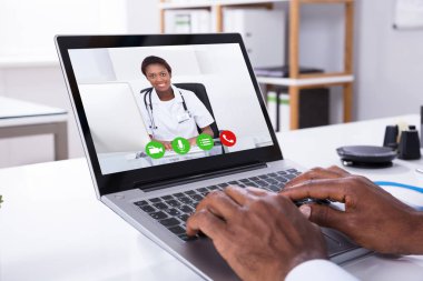 Bir kişi Video konferans aracılığıyla dizüstü erkek doktor ile yakın çekim