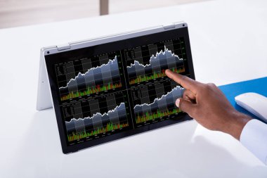 Laptop ekran üzerinde stok grafik üzerinde gösteren bir işadamı Close-up