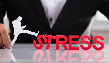 Kırmızı stres kelime yansıtıcı masa üzerinde tekme insan tutan işadamı rakam