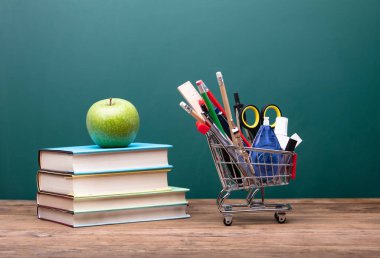 İleti örneği sepeti ahşap masa üzerinde Apple ile kitap yığını yakınındaki