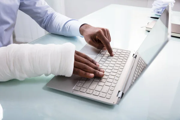 Nahaufnahme Eines Geschäftsmannes Mit Bandagierter Hand Mittels Laptop Arbeitsplatz — Stockfoto