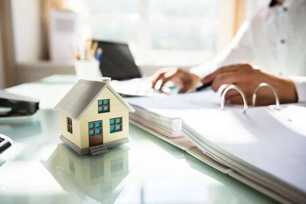 Mão Empresário Calculando Fatura Com Modelo Casa Escritório — Fotografia de Stock