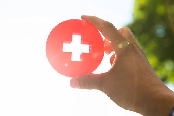 Närbild Mans Hand Röd Första Hjälpen Medicinsk Skylt — Stockfoto