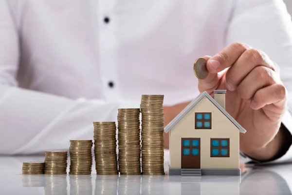 Zakenman Hand Met Munt Huis Model Reflecterende Bureau — Stockfoto