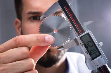 Bir adamın elini takımları boyutu dijital elektronik Vernier kumpas ile ölçme Close-Up
