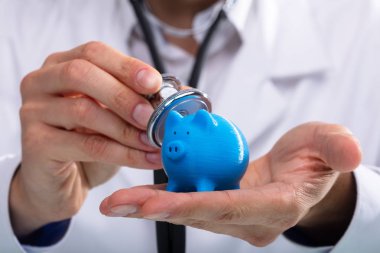 Piggybank stetoskop ile inceleyerek bir doktorun el Close-up