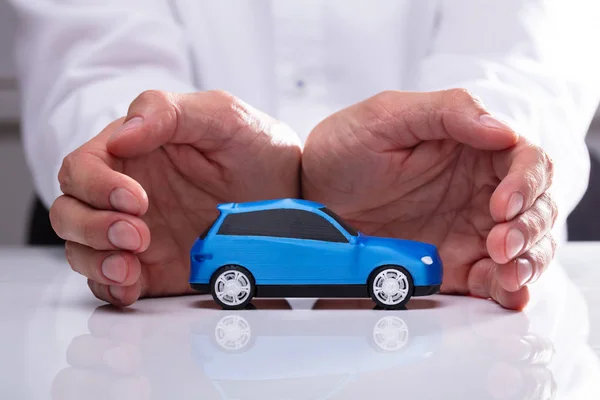 Mão Empresário Protegendo Pequeno Carro Azul Miniatura — Fotografia de Stock