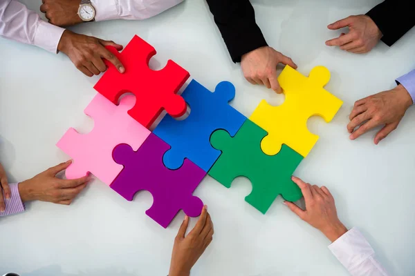 Group Businesspeople Colorful Solving Jigsaw Puzzle Desk Office — Stock Photo, Image