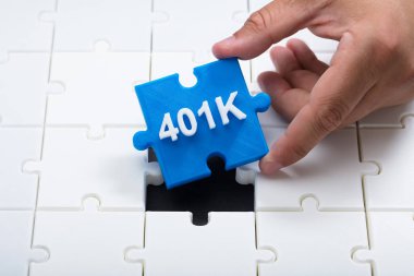 Close-up of a man's hand placing final blue 401k piece into jigsaw puzzle clipart