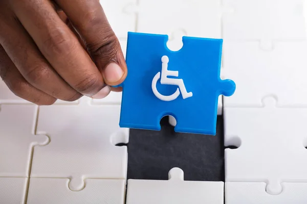 Person Hand Holding Piece Blue Jigsaw Puzzle Disabled Wheelchair Icon — Stock Photo, Image