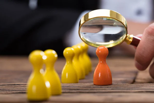 Mano Del Empresario Sostiene Lupa Sobre Peón Naranja Escritorio Madera — Foto de Stock