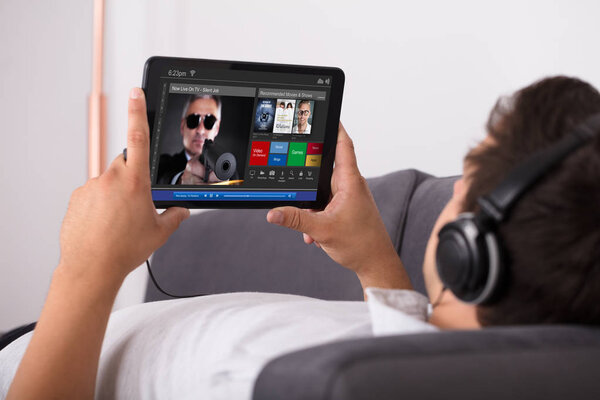 Man watching movie on website through digital tablet