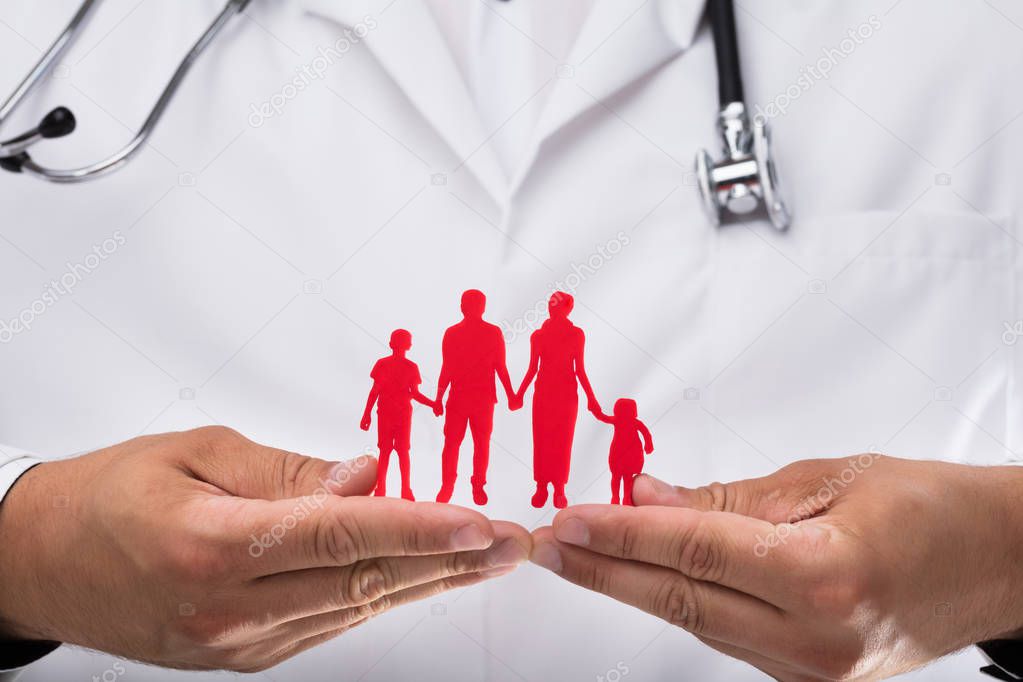 Photo of doctor's hand holding red family figures