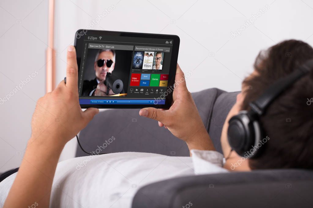 Man watching movie on website through digital tablet