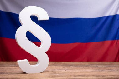 Yakın çekim Rus bayrağı önünde ahşap masa üzerinde beyaz paragraf sembolü