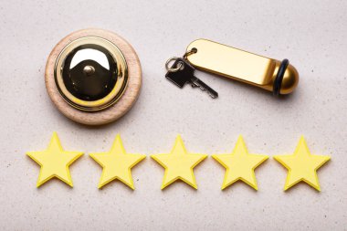 Hizmet Bell, otel anahtarı ve beş yıldızlı Rating simgesi yükseltilmiş görünümünü resepsiyon masası üzerinde