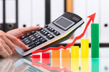 Ok yukarı doğru hesap makinesini kullanarak işadamının gidiş ile renkli grafik