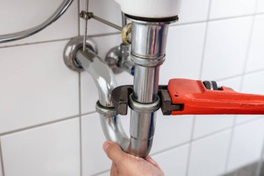 Yakın çekim bir tesisatçı 's el ile ayarlanabilir anahtarı lavabo tamiri
