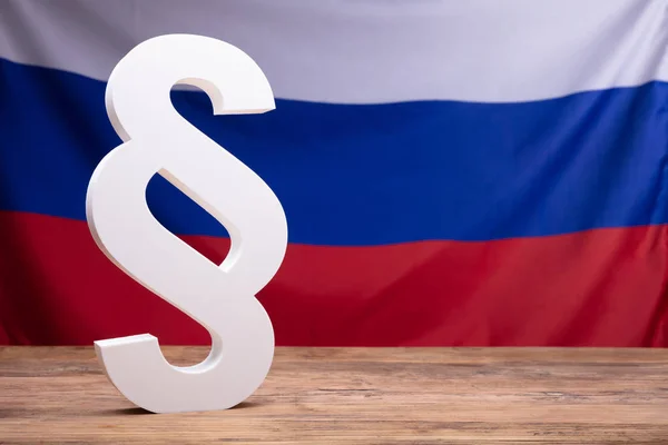 俄罗斯国旗前木桌上的白色段落符号特写 — 图库照片