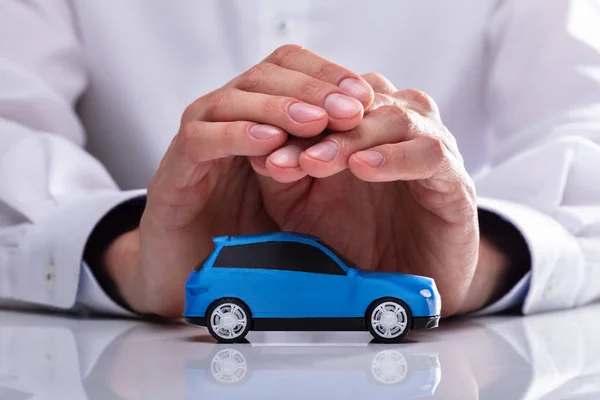 Mão Empresário Protegendo Pequeno Carro Azul Miniatura — Fotografia de Stock