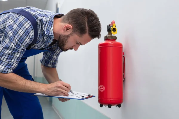 Joven Técnico Masculino Comprobando Símbolo Extintor Fuego —  Fotos de Stock