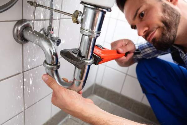 Male Plumber Hand Repairing Sink Pipe Leakage Adjustable Wrench — Stock Photo, Image