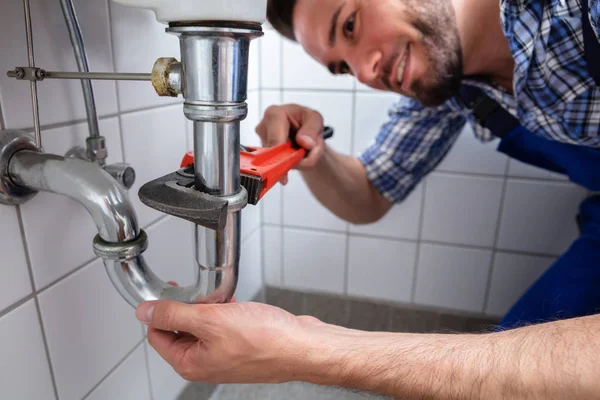 Jonge Mannelijke Loodgieter Repareren Spoelbak Met Verstelbare Moersleutel Badkamer — Stockfoto