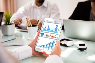 Ekranda grafikler ile dijital Tablet kullanarak bir iş kadını'nın ele Close-up